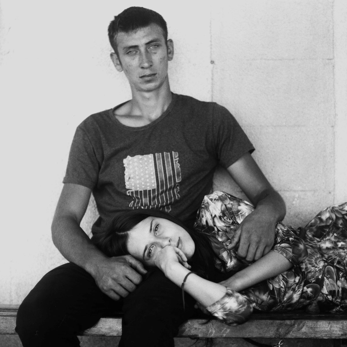 Black and white shot of a female lay across a mans lap