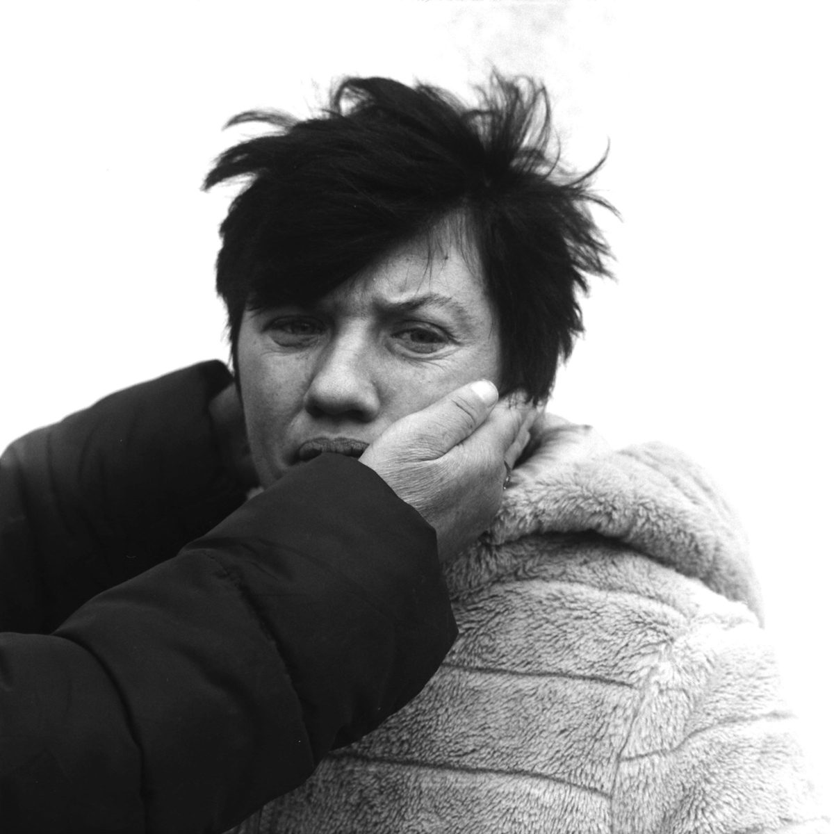Black and white shot of a woman with hand wrapped round her