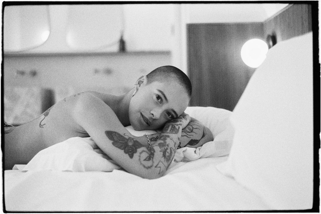 Black and white portrait of a woman on a bed