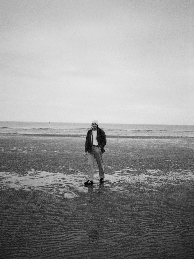 Black and white shot of a man on a beach