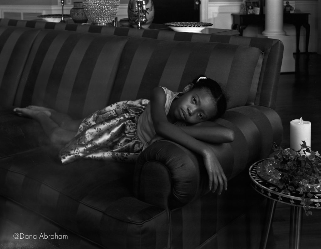 Black and white portrait of a girl lay on a sofa