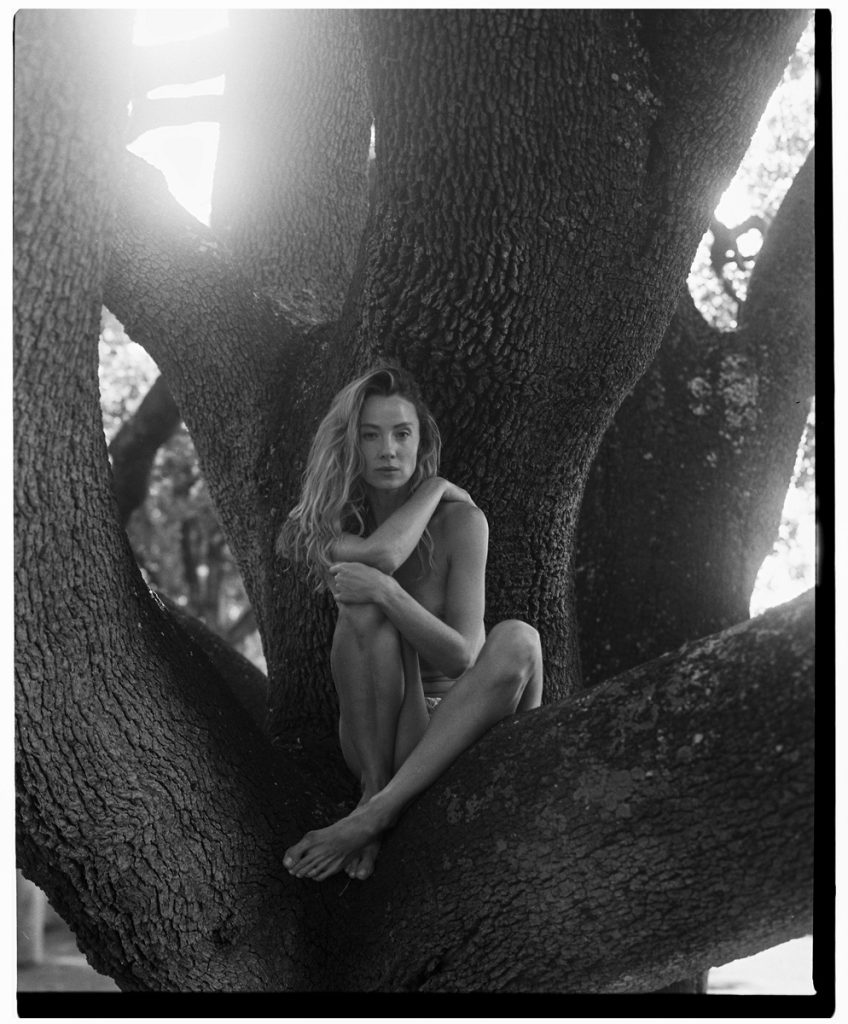 Black and white picture of a naked lady in the tree