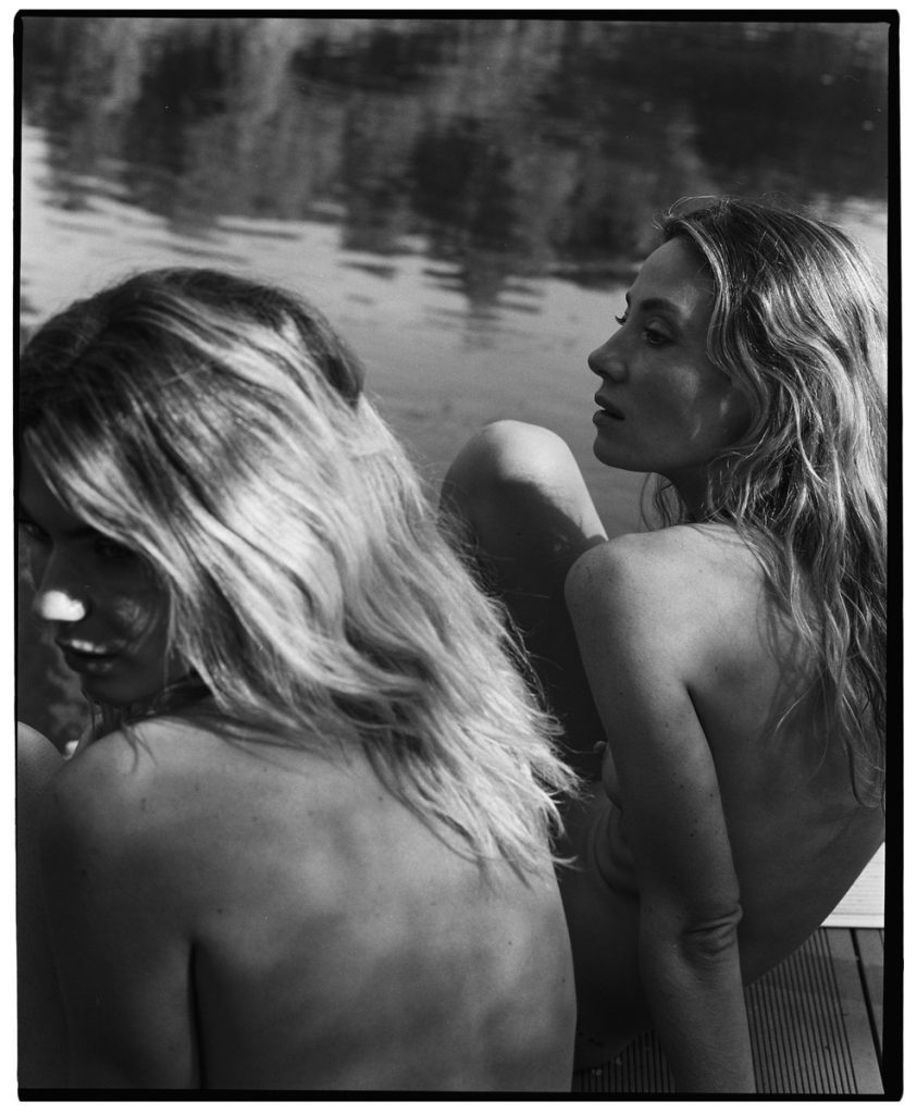 Black and white picture of two naked woman sat down