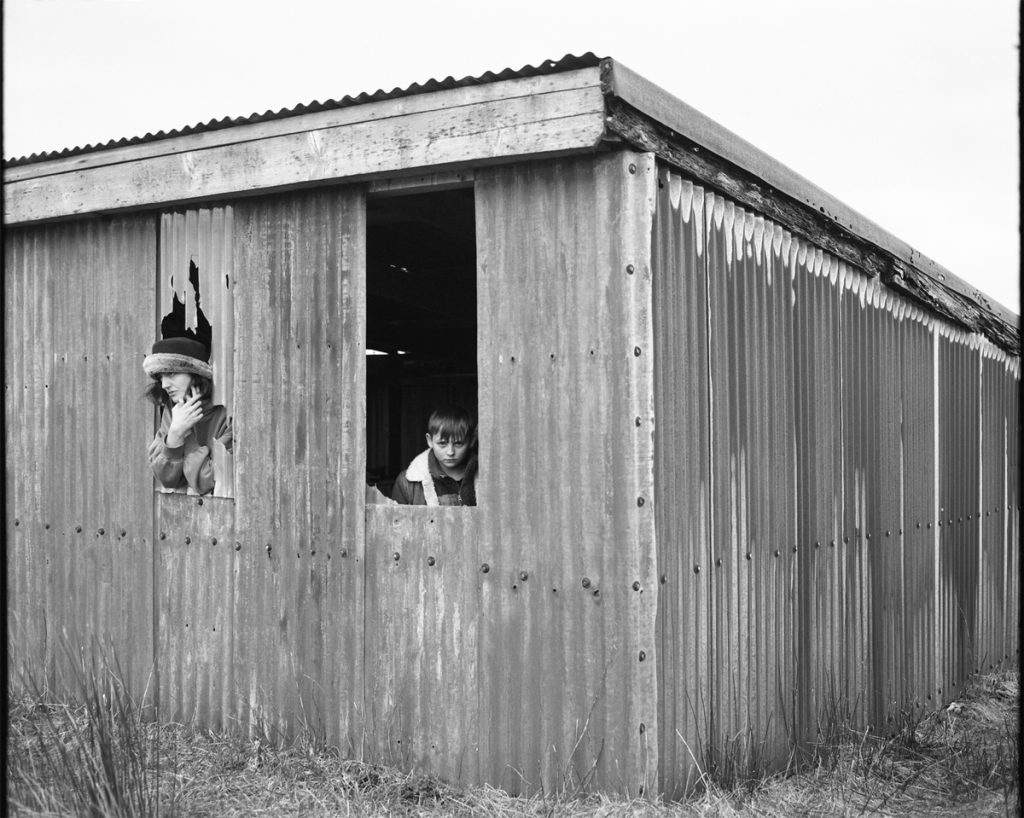 Black and white photo of a boy and woman in a shed