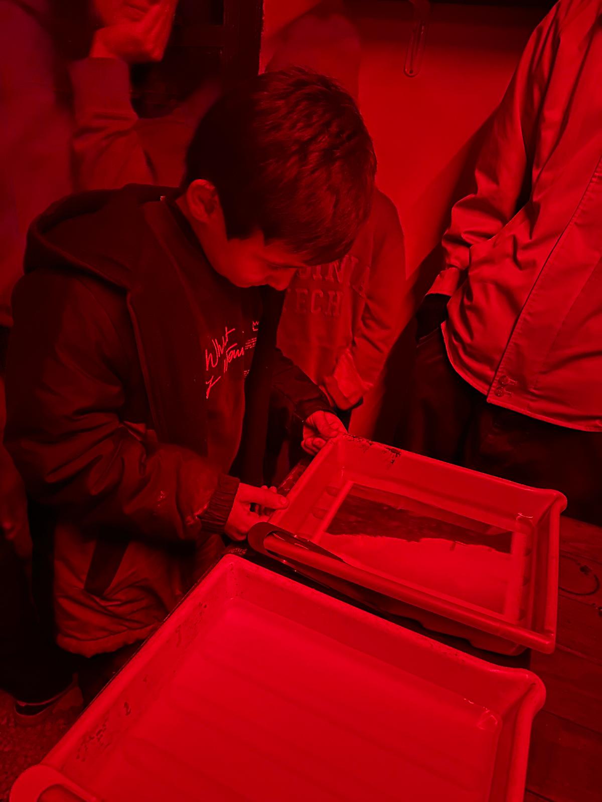 Children learning in the darkroom at Fotohane Darkroom