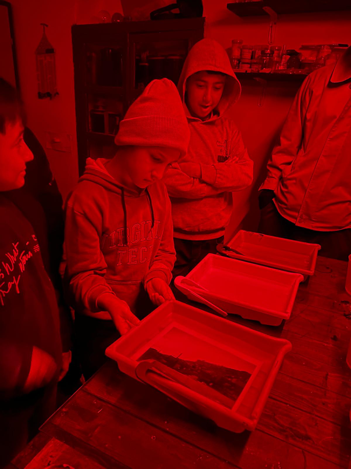 Children learning in the darkroom at Fotohane Darkroom