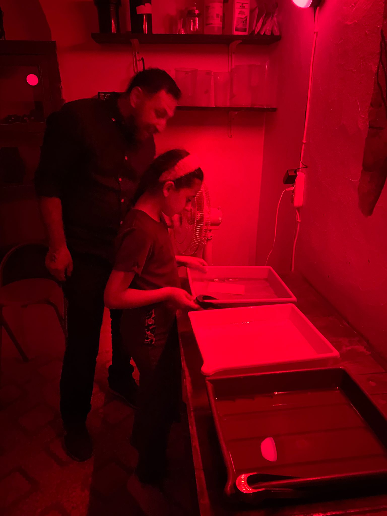 Children learning in the darkroom at Fotohane Darkroom