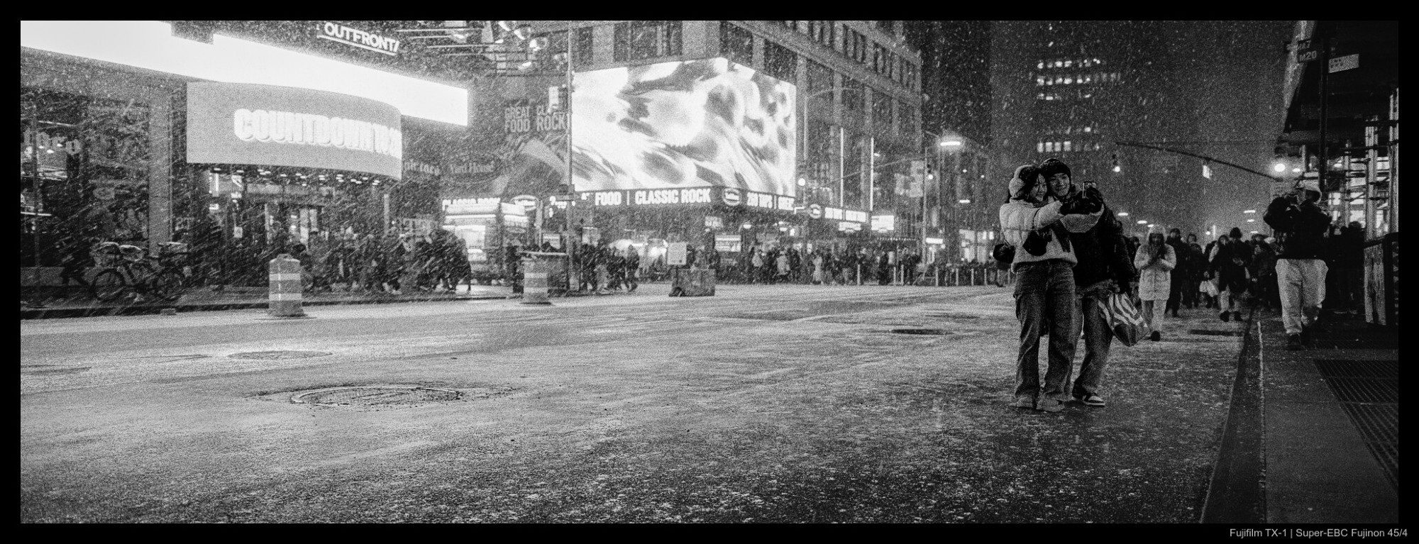 ‪Elengale‬ ‪@elengale.com‬ · 2d Sharing a moment together amidst a large crowd amidst a snowstorm. #fujifilmtx1 #35mm #filmphotography #analogphotography #film #nyc #streetphotography #believeinfilm #xpan #hasselbladxpan #panorama #ilford #delta3200 #fridayfavourites #2025fave